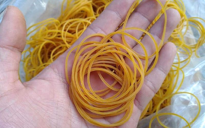 Bàn tay cầm dây thun vàng, hình ảnh có độ phân giải 500x800, chất lượng HD, chủ đề dây thun đa năng.