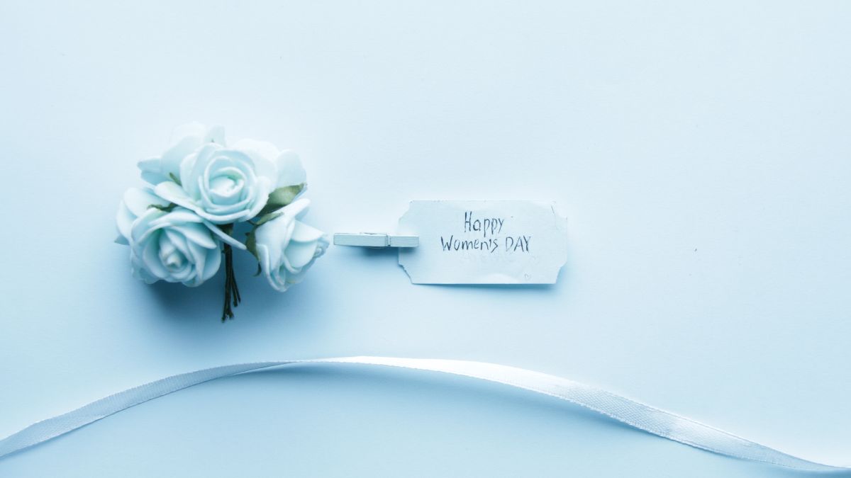 Bó hoa trắng tinh tế trên nền xanh nhạt, chữ "Happy Women's Day", ảnh HD 675x1200, chủ đề ngày Quốc tế Phụ nữ.