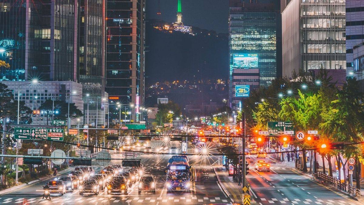 Phố đêm Seoul sôi động với ánh đèn rực rỡ, tòa nhà cao tầng, ảnh HD 1080x1920, phong cảnh đô thị hiện đại.